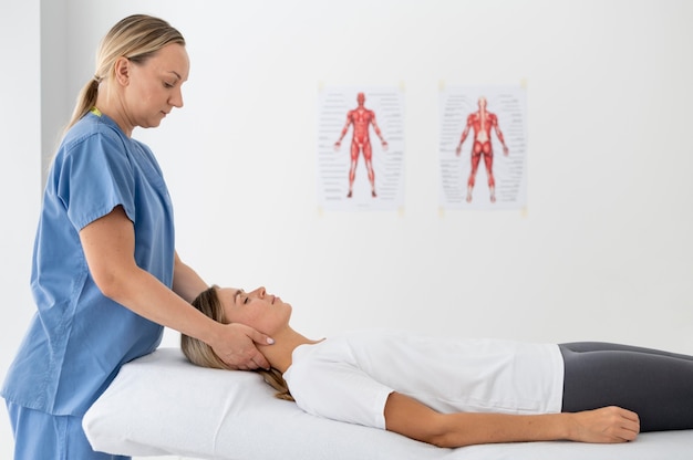 Free photo physiotherapist helping a young female patient