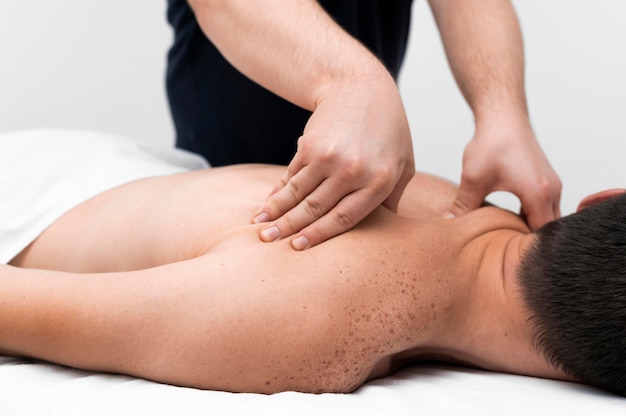 Physiotherapist massaging a male patient's back