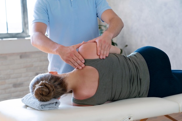 Foto gratuita fisioterapista che massaggia paziente da vicino