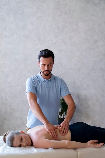 Physiotherapist massaging woman medium shot