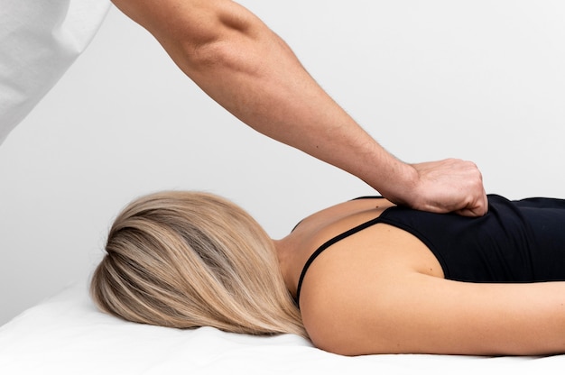 Fisioterapista che massaggia la schiena della donna