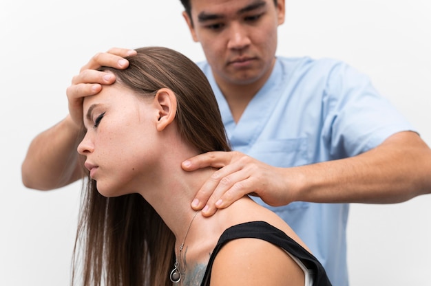 Foto gratuita fisioterapista che massaggia il collo della donna