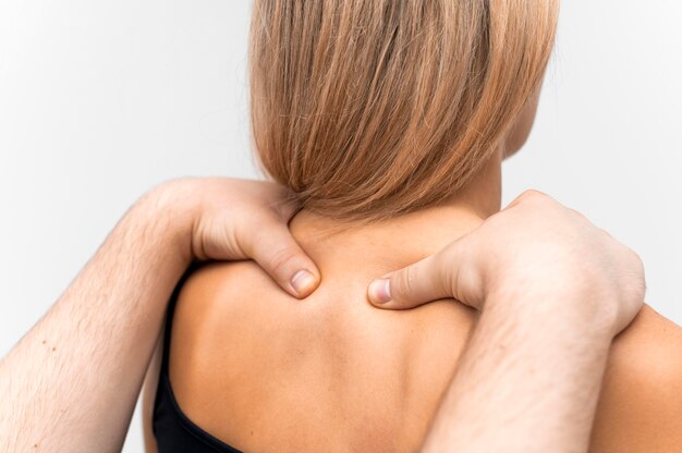 Physiotherapist massaging woman's neck