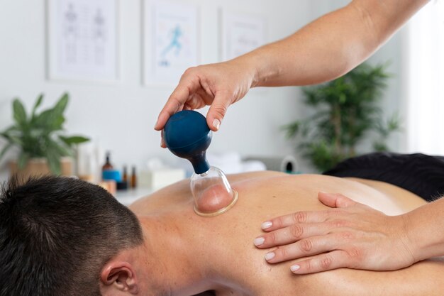 Physiotherapist performing cupping session on male patient