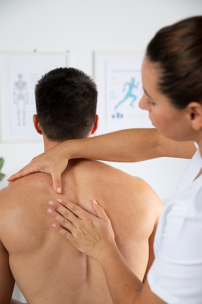 Physiotherapist performing therapeutic massage on male client