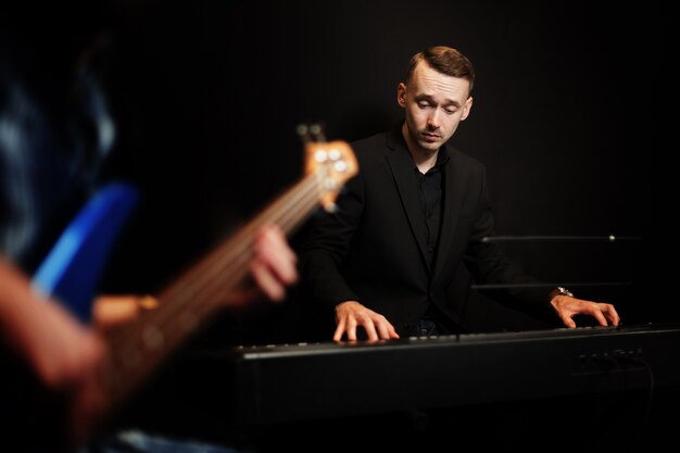 Pianist with guitar in foreground