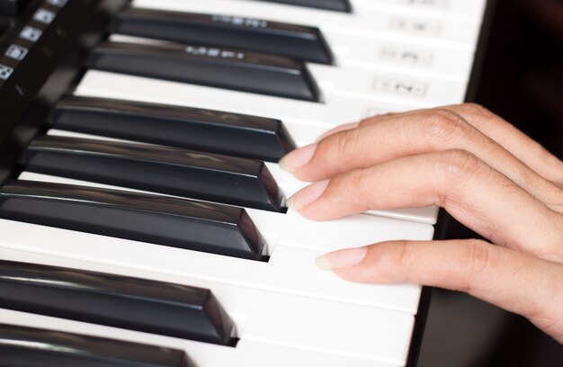 女性とピアノのキーボード