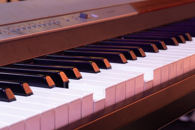 Piano keys on a beautiful colored background close up.