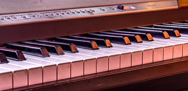 Piano keys on a beautiful colored background close up.