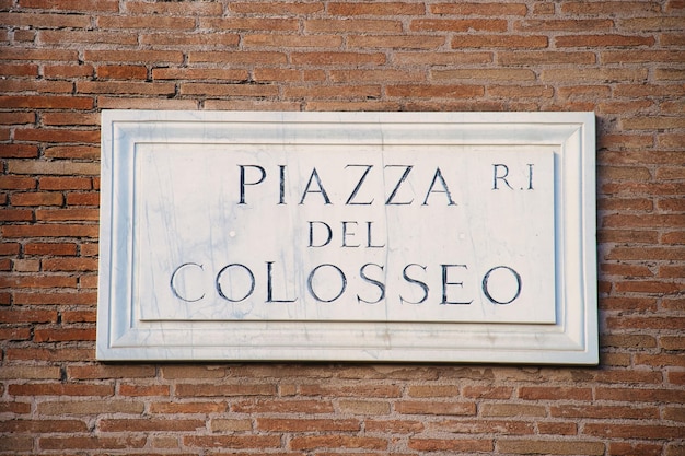 Free photo piazza del colosseo sign on a brick wall