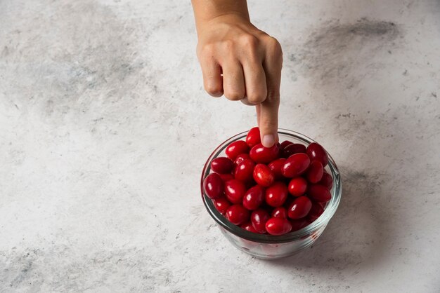 Raccogliendo un corniolo rosso dalla tazza.