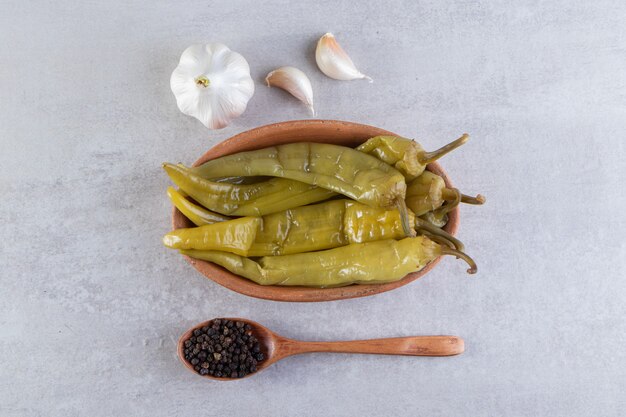 Pickled chili pepper placed on a stone surface. 