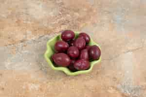 Free photo pickled cornel cherries in green bowl