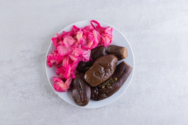 Pickled eggplants placed on a stone surface.