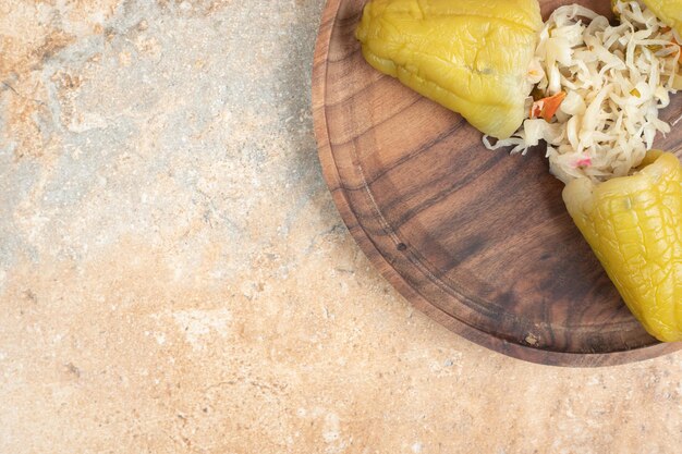 Pickled peppers stuffed with sauerkraut on wooden plate