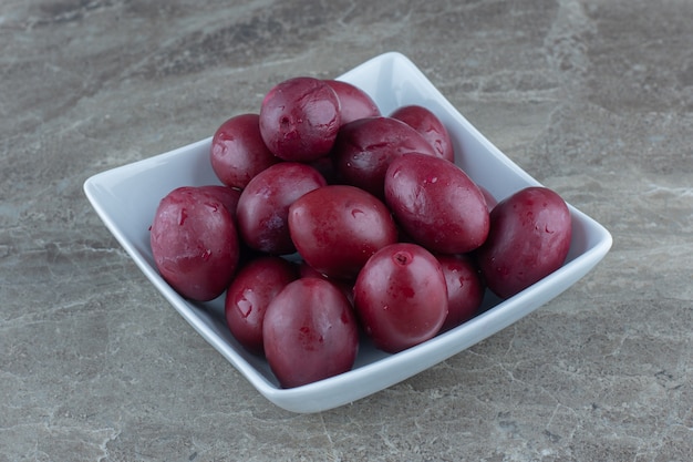 Pickled pile of olives in white ceramic bowl