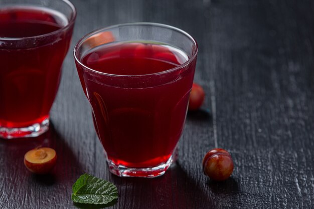 Pickled Plums on the dark surface.