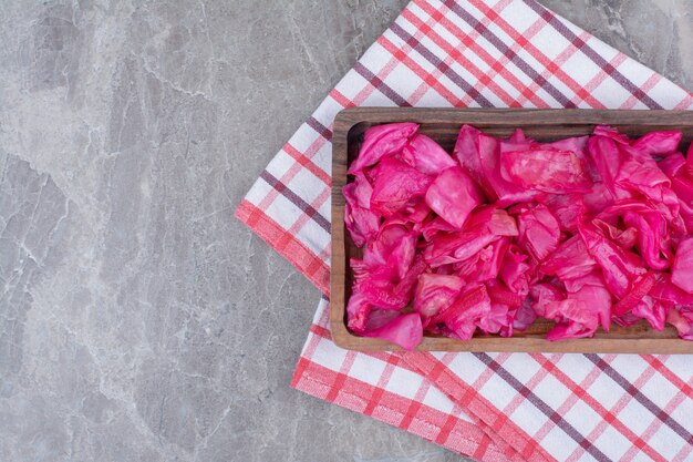 Pickled red cabbage on wooden plate.