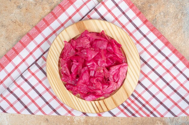 Pickled red cabbage on wooden plate.