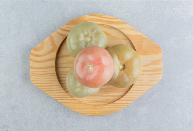 Pickled tomatoes on a wooden plate  