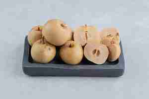 Free photo pickles cucumber and apples on wooden plate on the marble surface