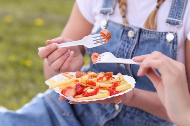 ピクニック。女性は屋外の食べ物を食べています