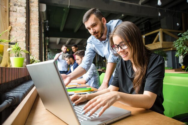 Picture of beautiful lady in glasses listening to her partner ot colleague Businesswoman working on laptop computer in restaurant or cafe