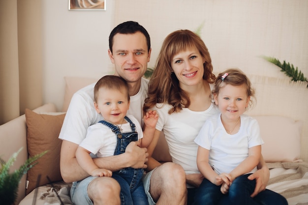 Picture of beautiful mother, father and two caucasian children have fun together and smiles