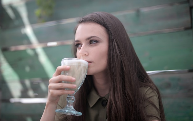 コーヒーを飲む魅惑的な緑色の目を持つ美しい女性の写真