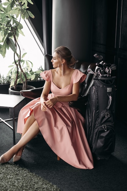 Free photo picture of a charming caucasian lady sits on the black leather armchair and poses for the camera