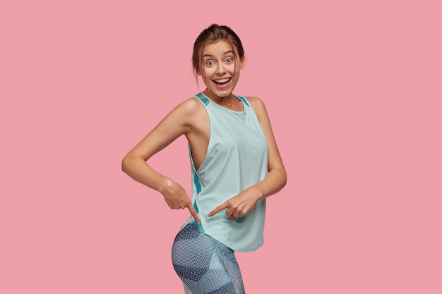 Picture of glad woman points at buttocks