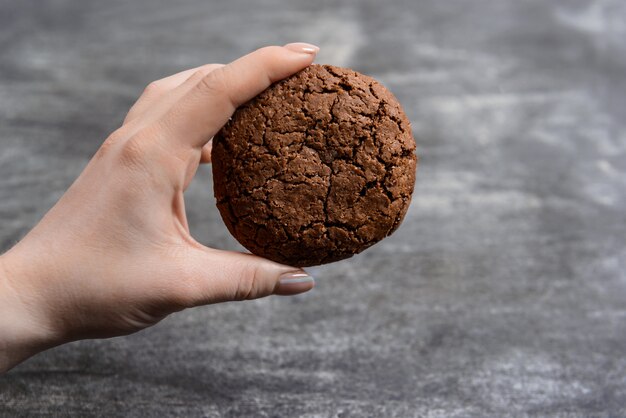 チョコレートクッキーを握る手の写真