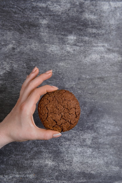 Изображение руки держат шоколадное печенье