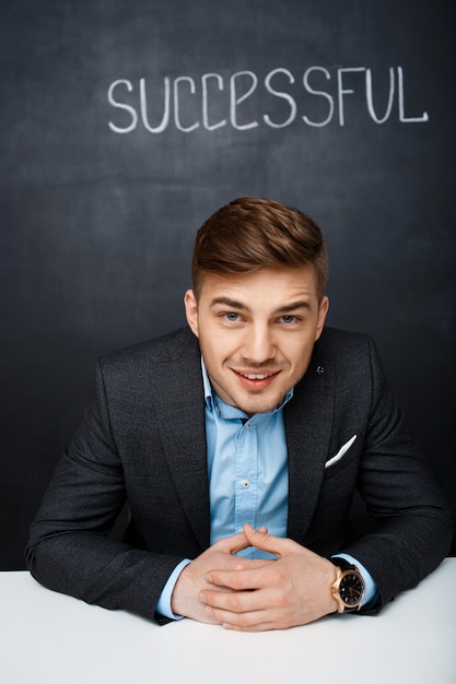 Free photo picture of a happy man over black board with  text successful