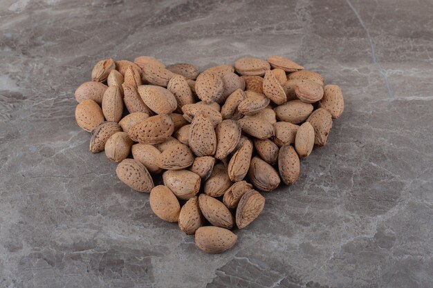 A picture of a heart made of almonds on the marble surface