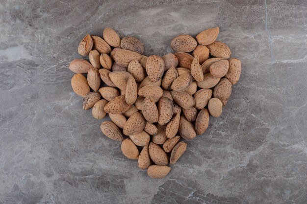 A picture of a heart made of almonds on the marble surface