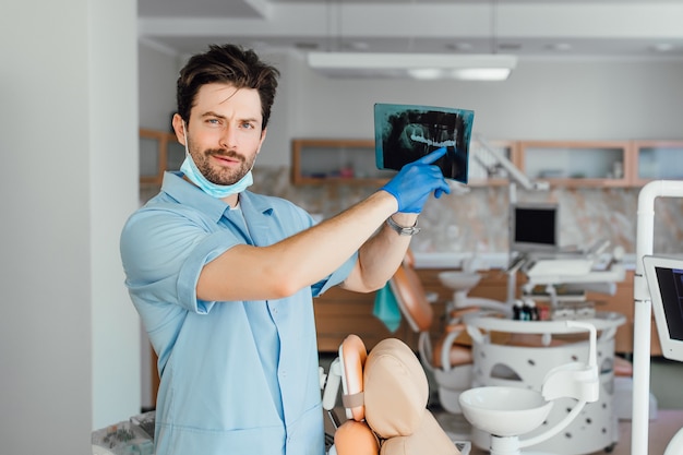 Picture of male doctor or dentist looking at x-ray, at his office.