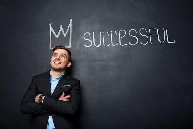 Free photo picture of man over blackboard with crown and text successful