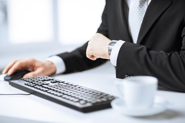 Picture of man hands typing on keyboard and watching time