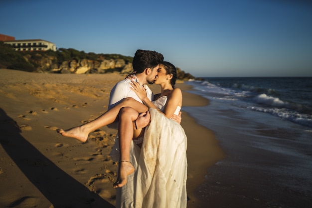 Фотография красивой пары, целующейся друг с другом в день свадьбы