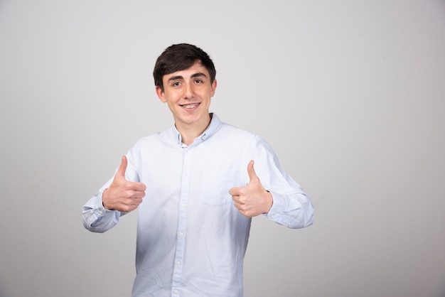 Picture of a positive man model standing and showing thumbs up