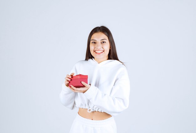 Picture of a pretty young girl model holding a gift box.