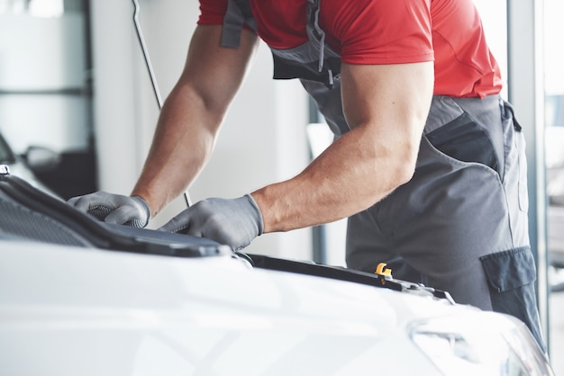 Picture showing muscular car service worker repairing vehicle.