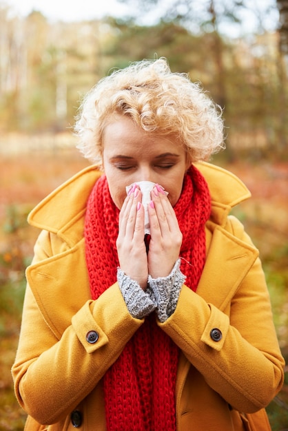 Free photo picture of sneezing woman with tissue in hands