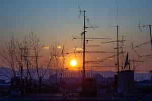 Free photo picture of tree and tv antenna silhouettes on the roof during the sunset in zagreb in croatia