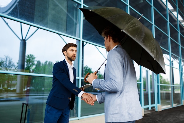 Picture of  two young businessmen meeting at station