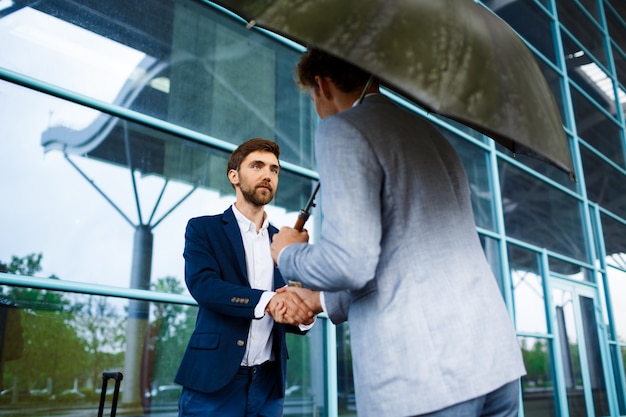 Picture of  two young businessmen meeting at station