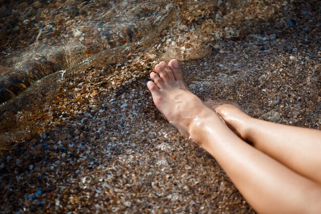 아침에 해변에서 어린 소녀의 다리 사진