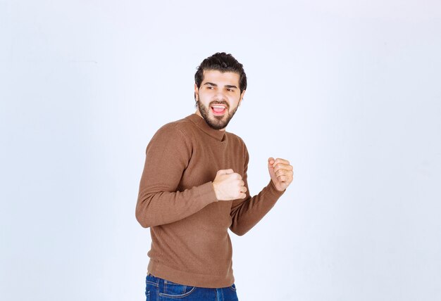 Picture of a young handsome man model standing and posing with fists . High quality photo