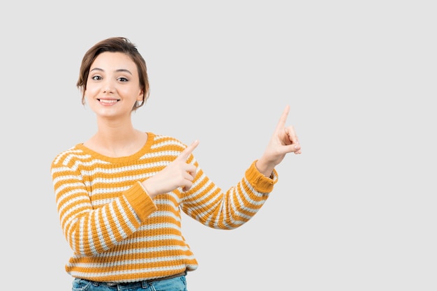 Free photo picture of a young woman pointing up with fingers